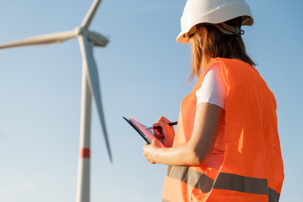 Female maintenance engineer controls the work of wind turbines and windmills. Renewable energy