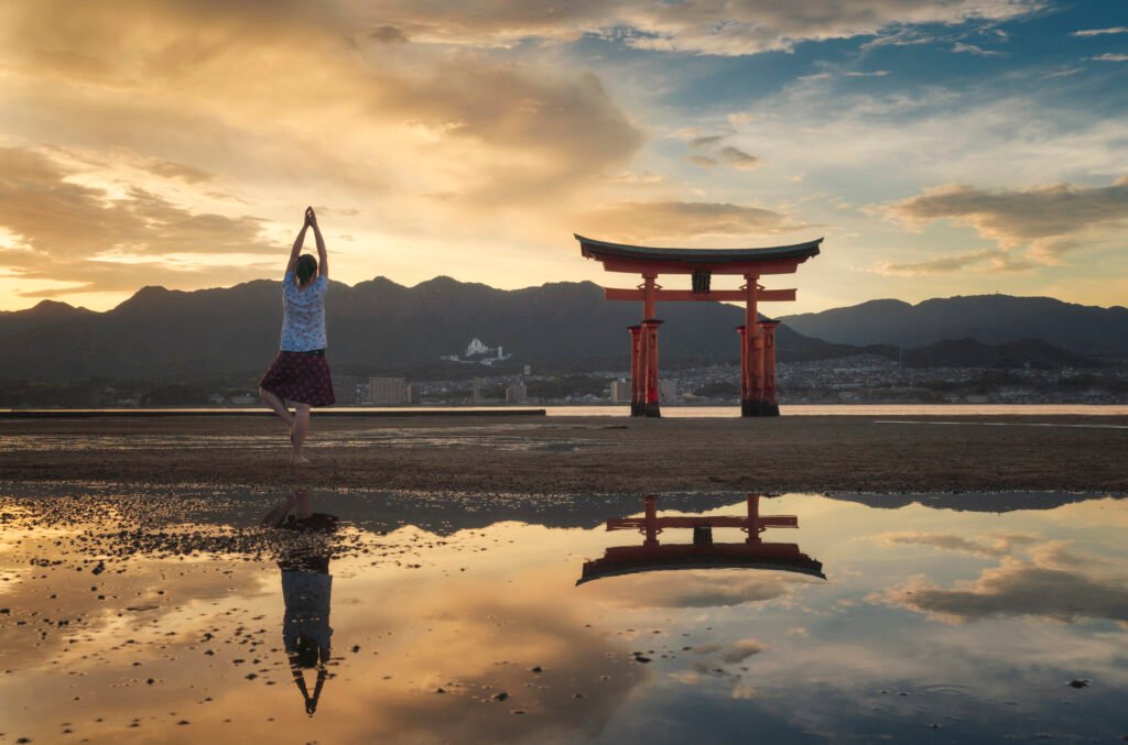 Woman enjoying the sunset on Itsukushima Island or Miyajima, Hiroshima, Japan